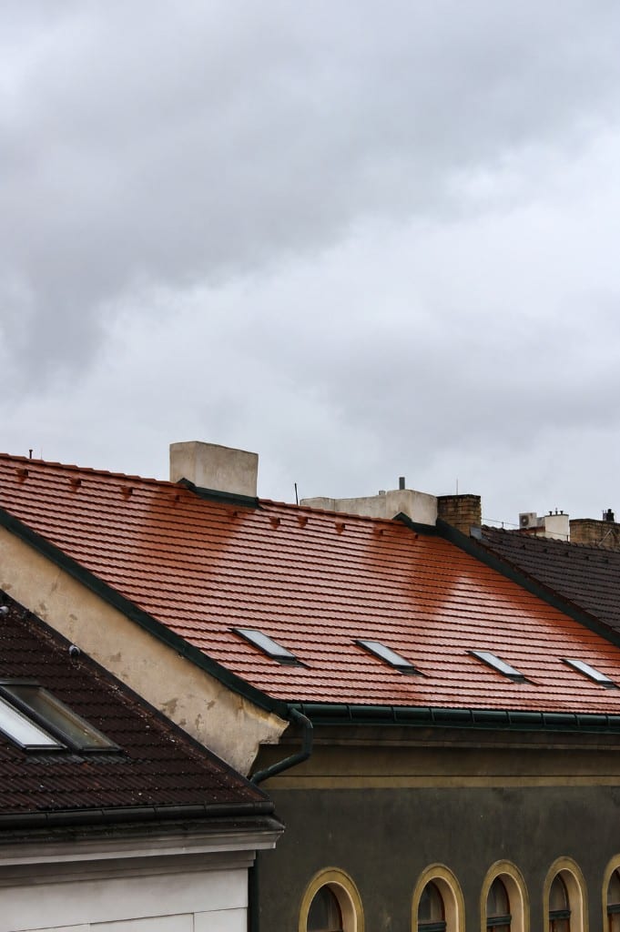Orange tile roof with a row of skylights and chimney