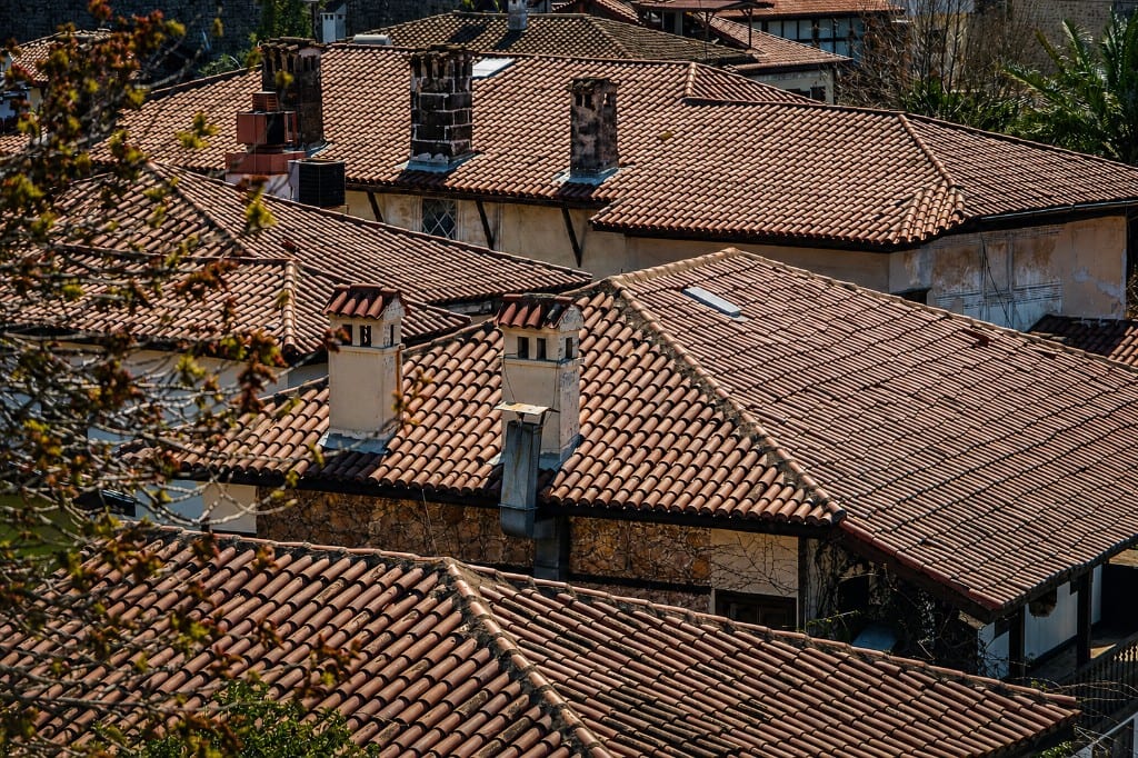 Cluster of Mediterranean clay tile roofs and chimneys